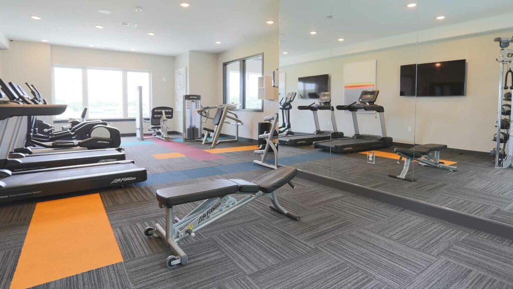 Community gym equipped with various fitness equipment at Element Oakwood.
