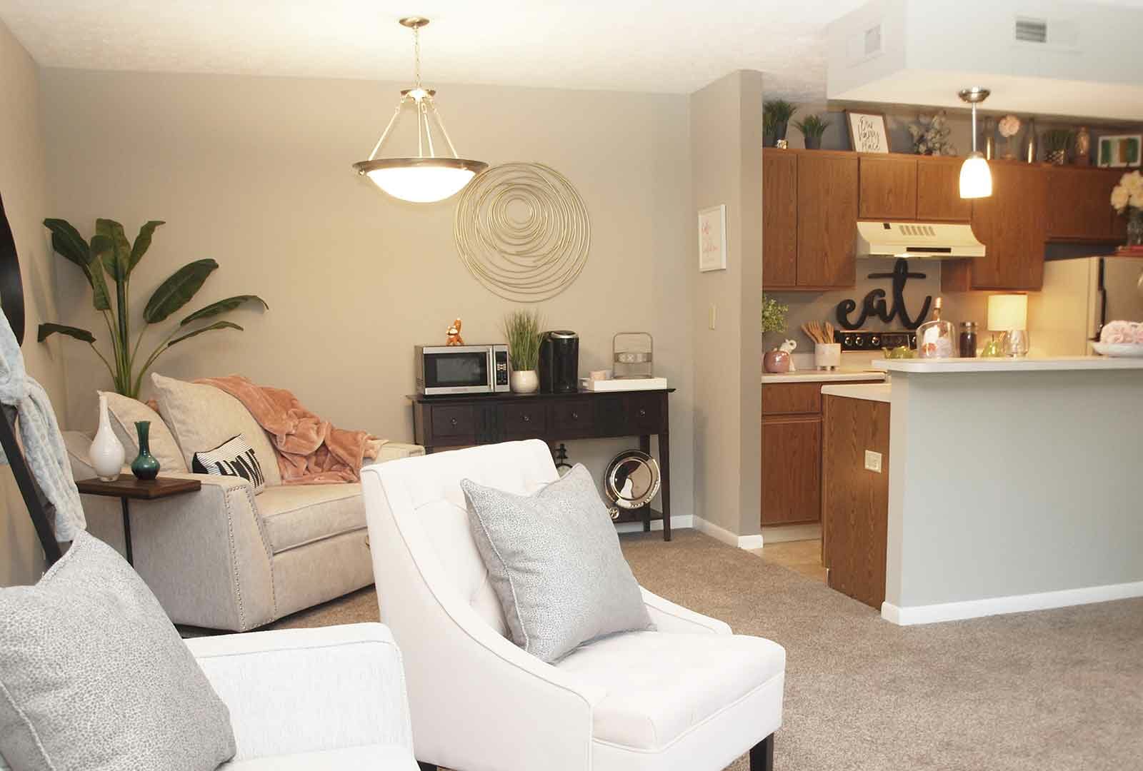 Carpeted living room space next to kitchen at Fox Chase North.