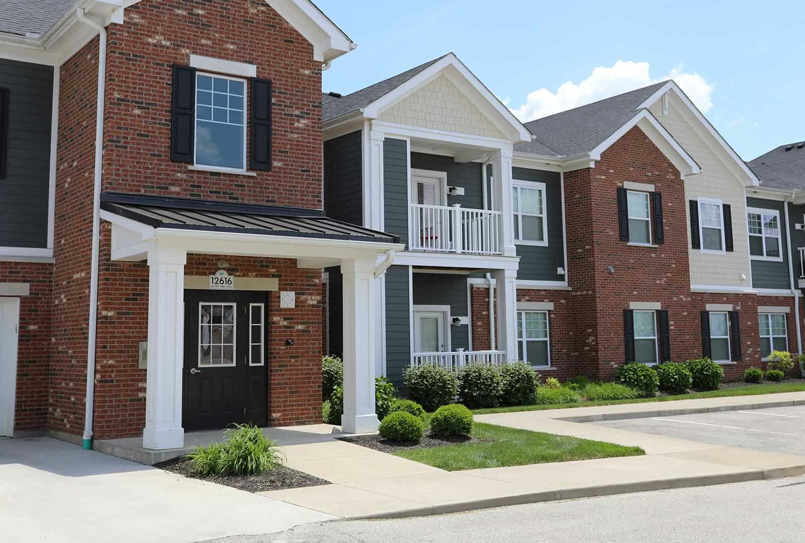 Exterior of apartment entrance at Kendal on Taylorsville with balconies and landscaping.