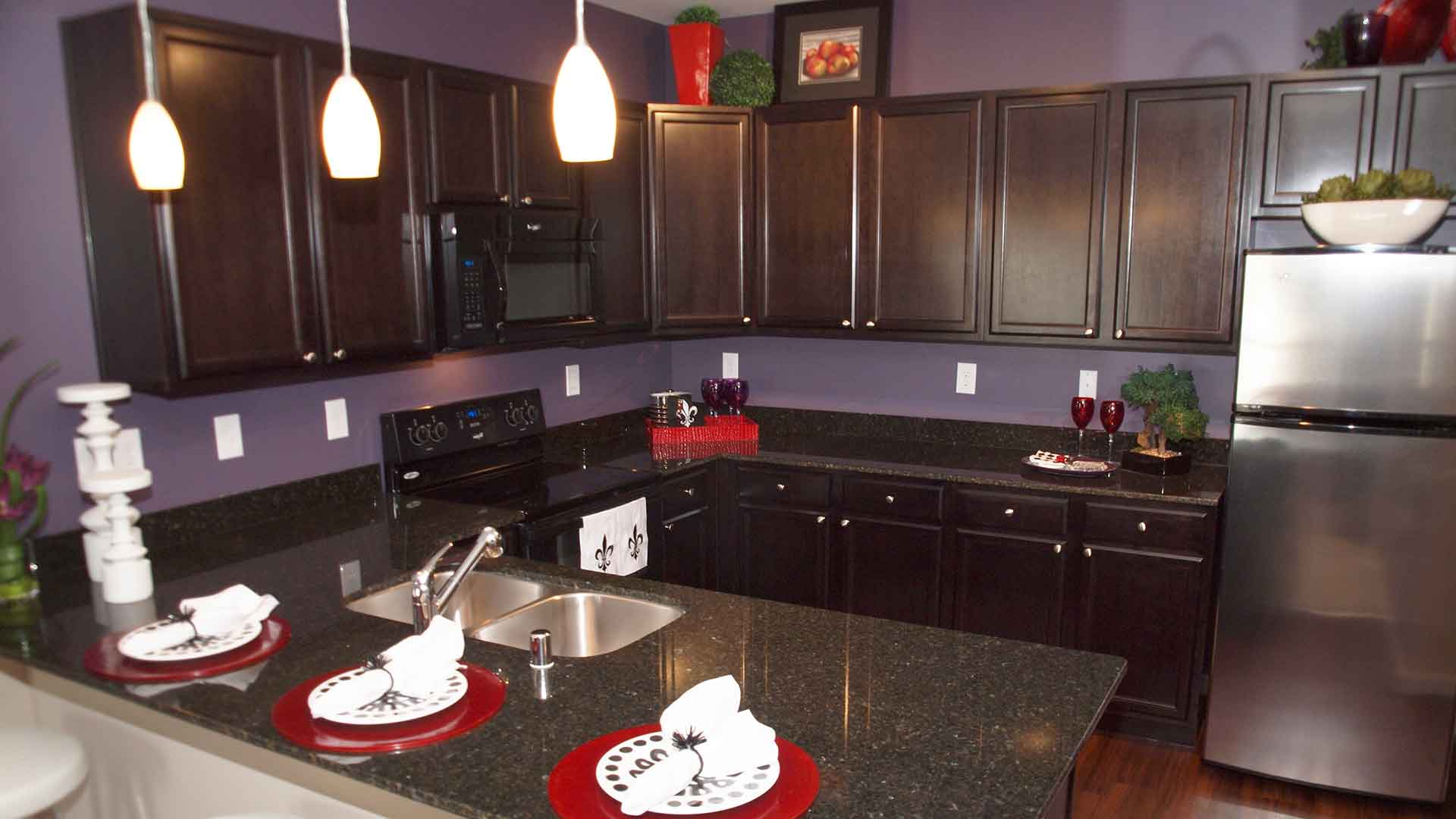 Kitchen with dark appliances and solid wood cabinets.