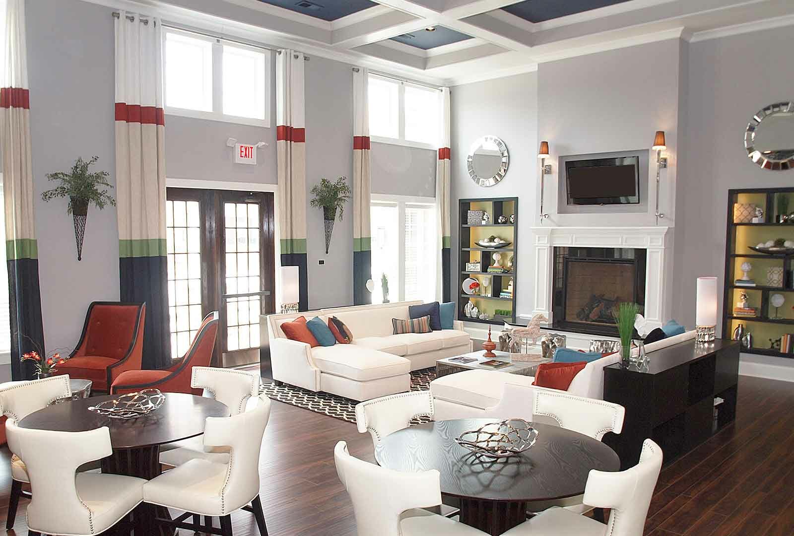 Beautiful clubhouse with lounge chairs, tables, and fireplace.