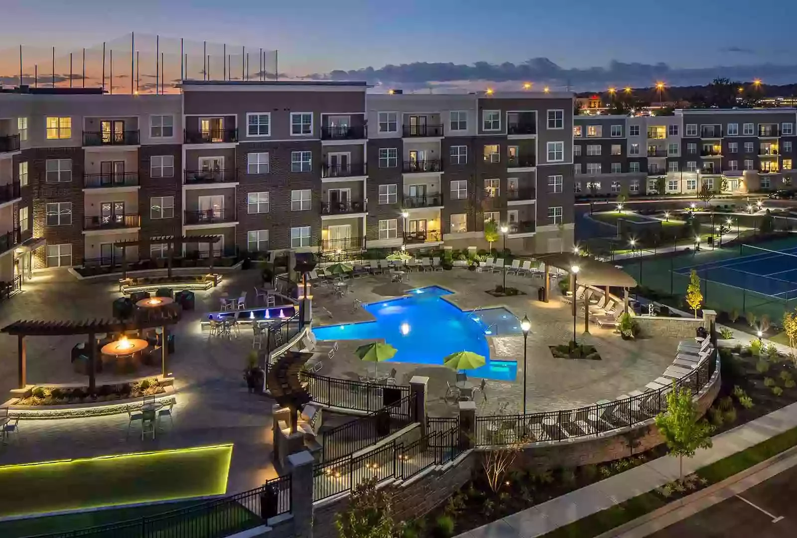 Aerial view of the resident retreat which includes a patio, swimming pool, and tennis court.