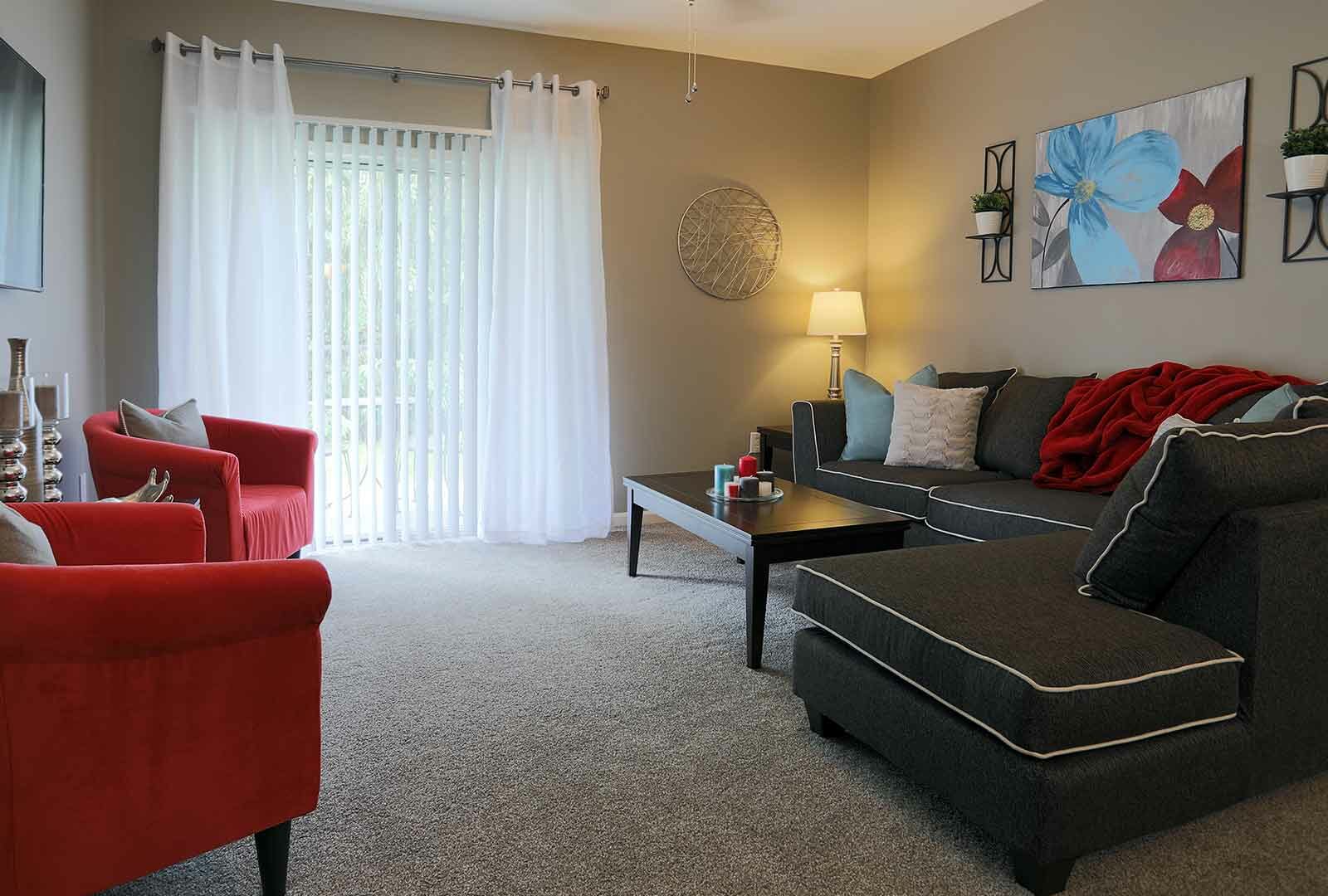 Decorated living room space with sliding patio door at Wellington Place.