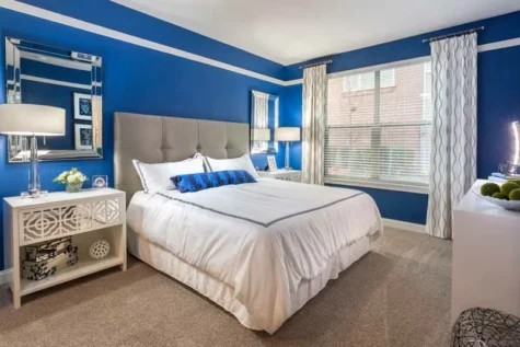 Master bedroom at 49Hundred with carpet flooring and a large window.