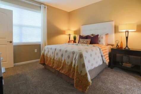 Carpeted bedroom furnished with a full size bed at Brinley Place.