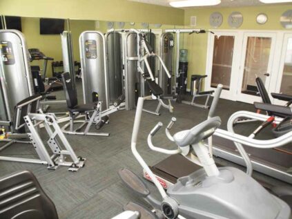 Fitness center with workout machines and mirrors.