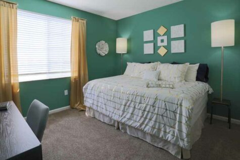 Decorated bedroom with large window at Emerald Lakes.