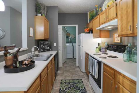 A spacious kitchen with full appliances attached to a laundry room at Emerald Lakes.