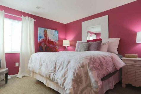 Apartment bedroom furnished with feminine decor.