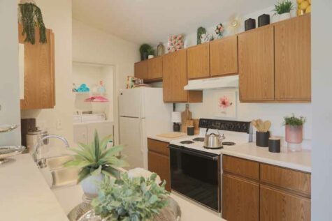 Kitchen with wooden cabinets connected to in-unit laundry room.