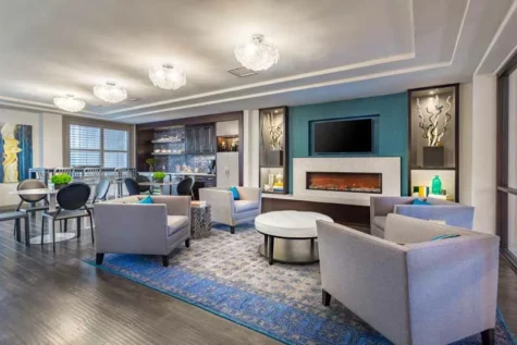 Modern resident lounge with a fireplace and coffee bar.