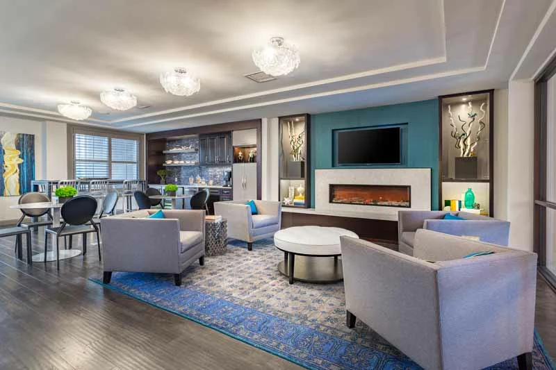 Modern resident lounge with a fireplace and coffee bar.