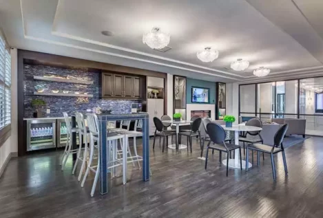 Modern resident lounge with a fireplace, coffee bar, and seating.