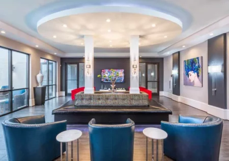 Modern community event space with a TV, seating, and kitchen area.