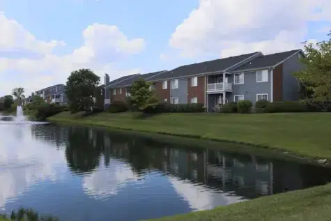 Apartment buildings surrounding a small lake with fountain.