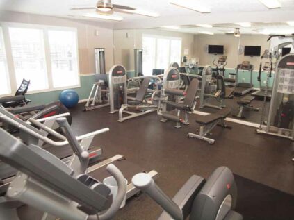 Fitness room equipped with gym equipment and treadmills.
