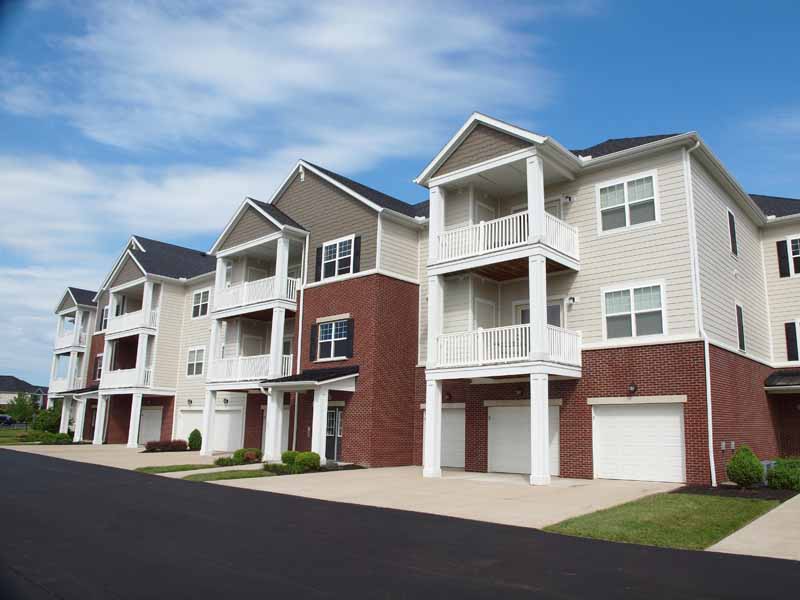 Palmera apartment building entrance with garages and balconies.