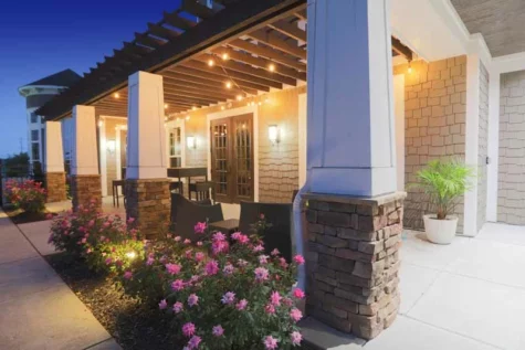 Spacious, furnished poolside outdoor patio space in the evening.