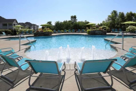 Lounge chairs lining the resort-style pool at Palmera.