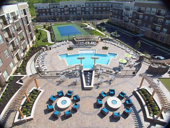 Aerial view of the resident retreat which includes a patio, swimming pool, and tennis court.