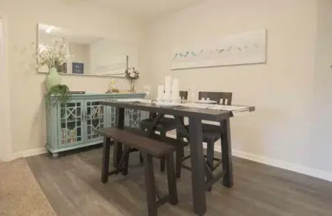 Kitchen table and buffet on hardwood flooring.