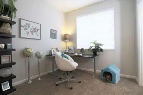 Office furniture in an apartment room with window.