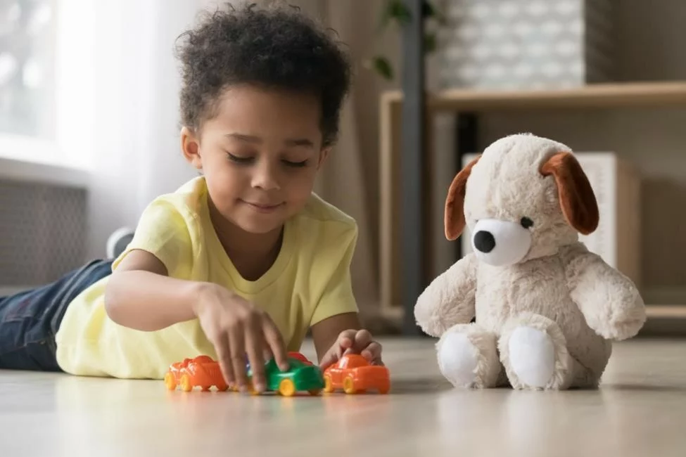 A small child playing with a stuffed animal