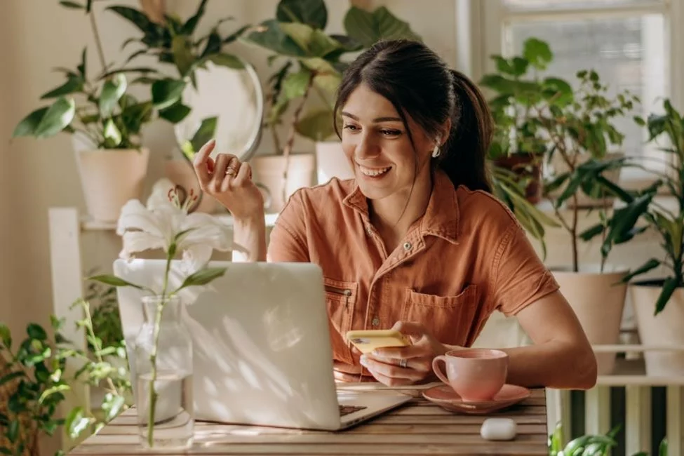 A woman sitting in her apartment den with her laptop
