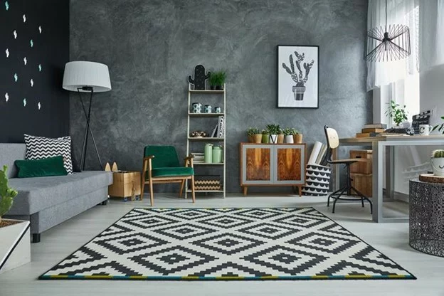 A grey multipurpose room with a desk and a couch