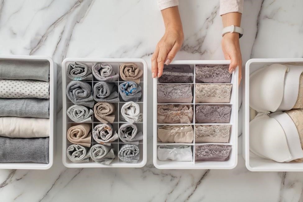 A woman organizing towels and clothing in boxes