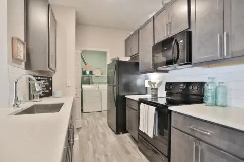 Kitchen with black appliances and dark cabinets