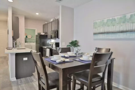Kitchen and dining room with black appliances and dark cabinets