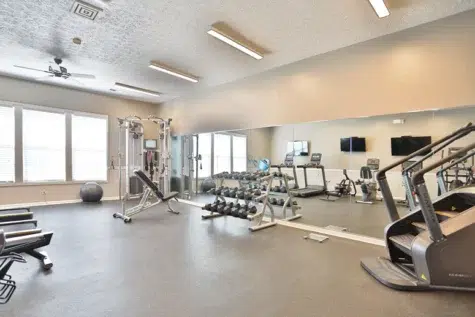 Shadow Ridge gym area. Mirror, cardio machines and weights.