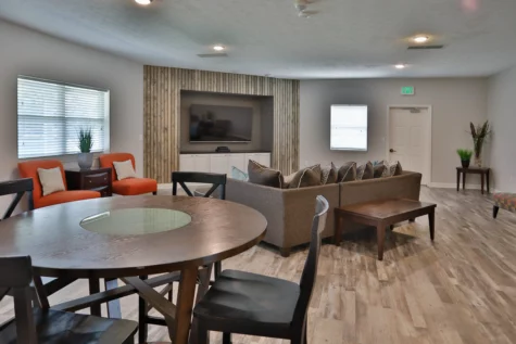 Clubhouse with tv, couch, table and seating area of Wellington Place Apartments in Fishers IN