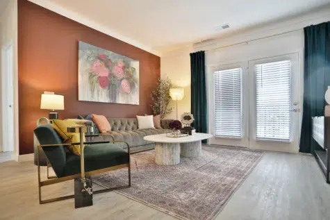 Living room with couch, chair and coffee table. Patio door. Clocktower West Chester, Ohio Apartments