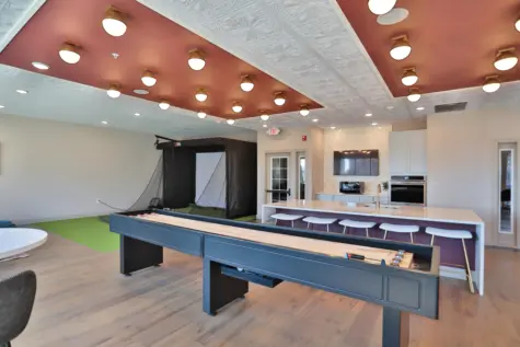 Another view of Clocktower's lounge area. Shuffleboard, golf simulator, kitchen area.