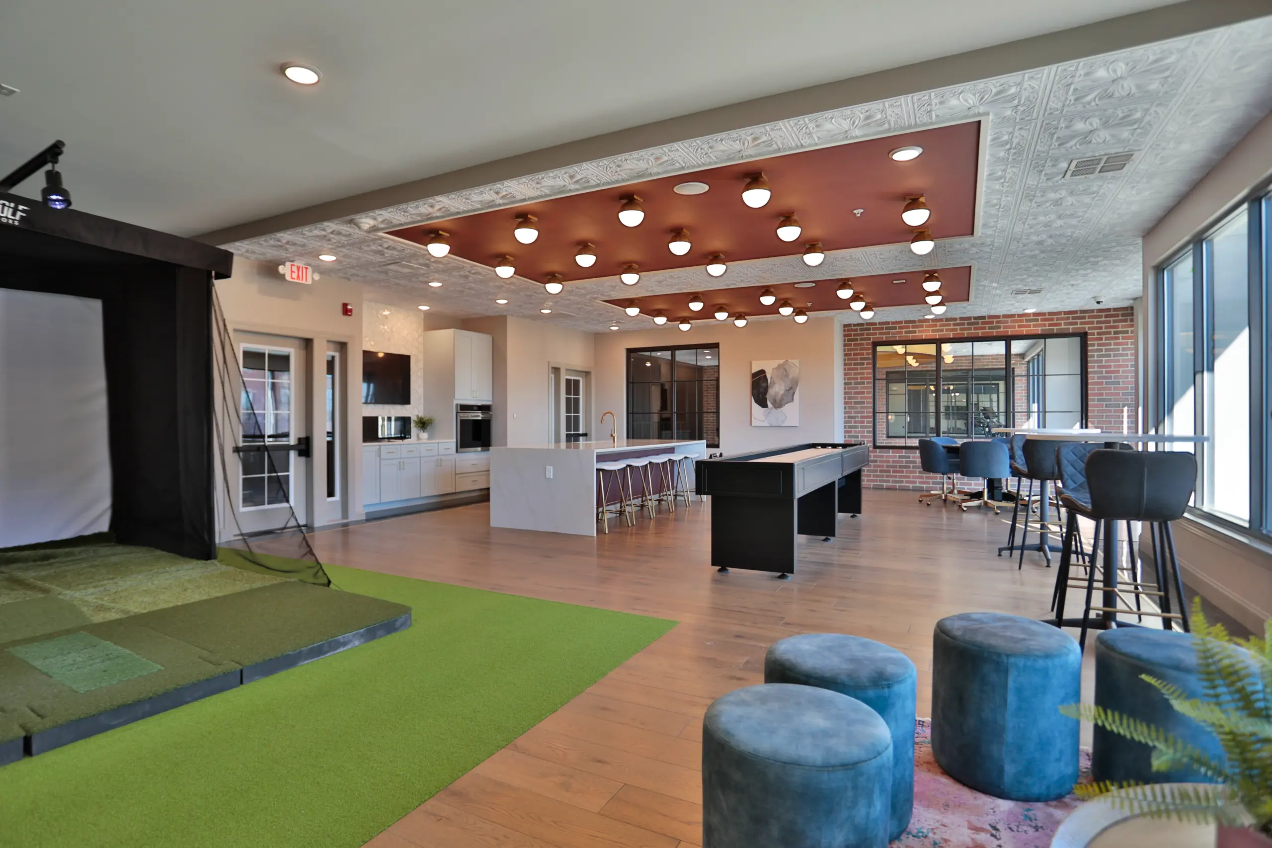 Clocktower West Chester Apartments club house area. Lounge area. Golf simulator, shuffle board and seated areas.