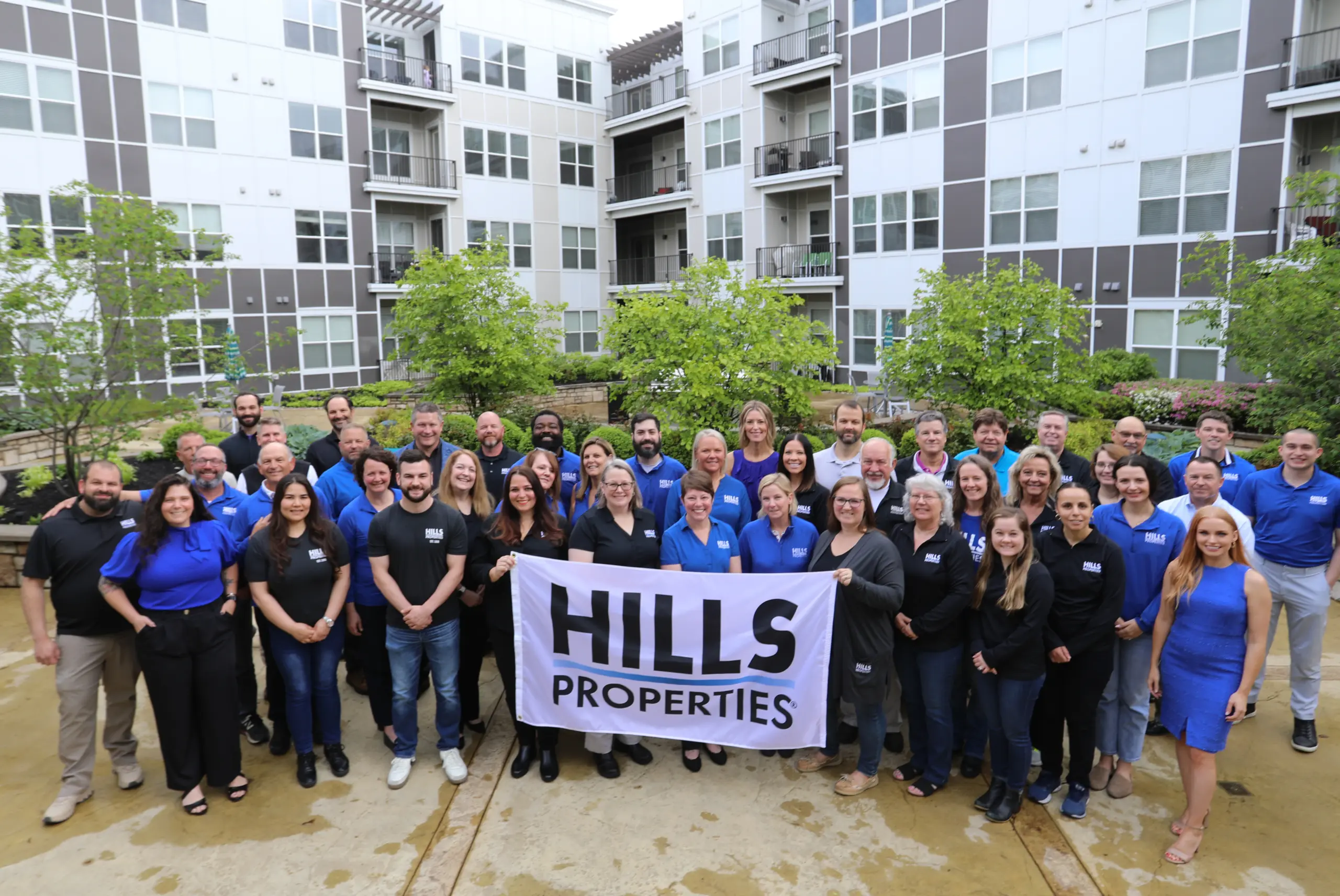 Hills Properties with staff holding up sign