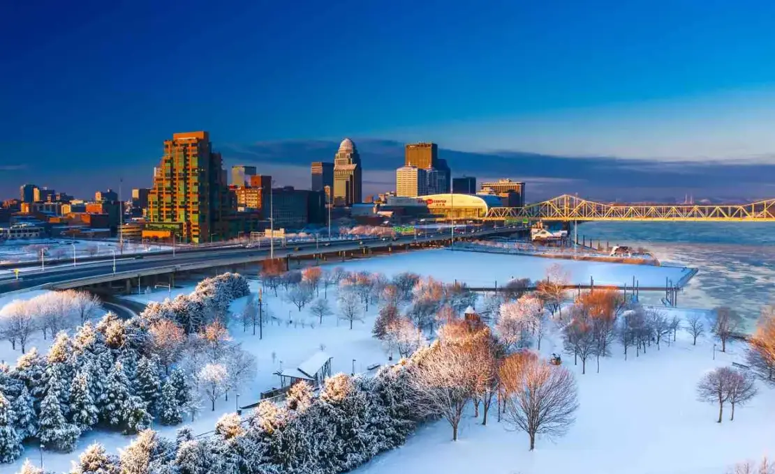an aerial view of city with snow, bridge and downtown