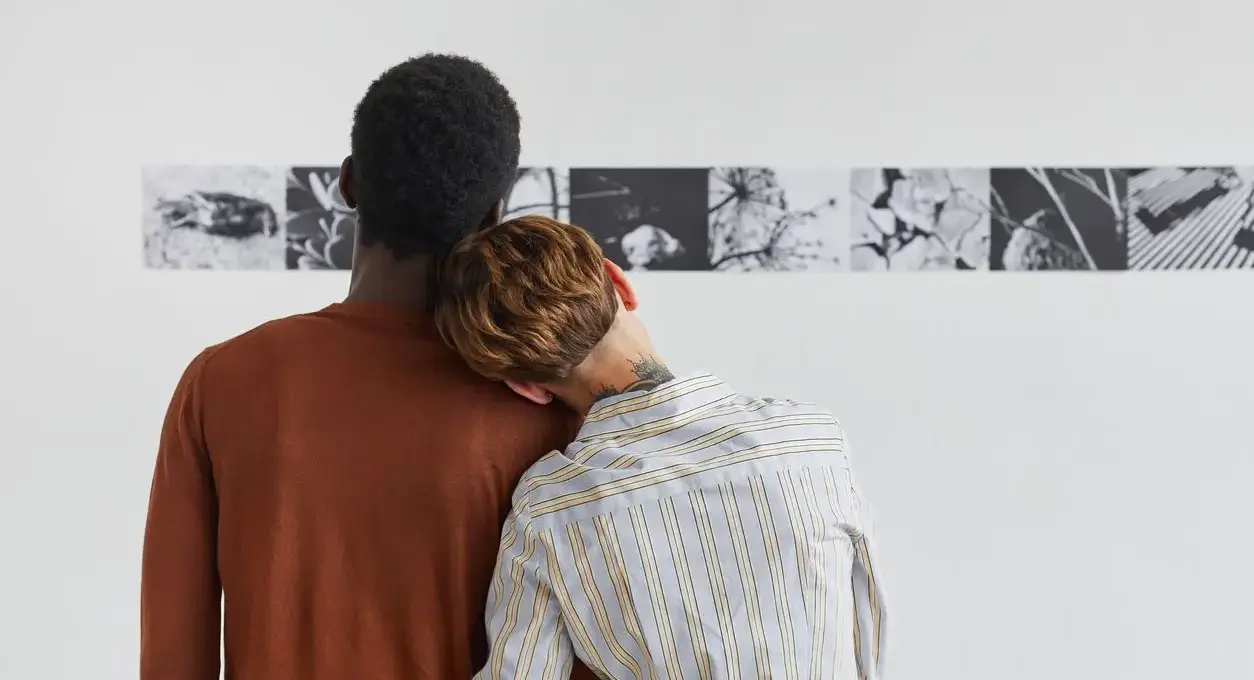 A young couple gazes at modern artwork on the wall
