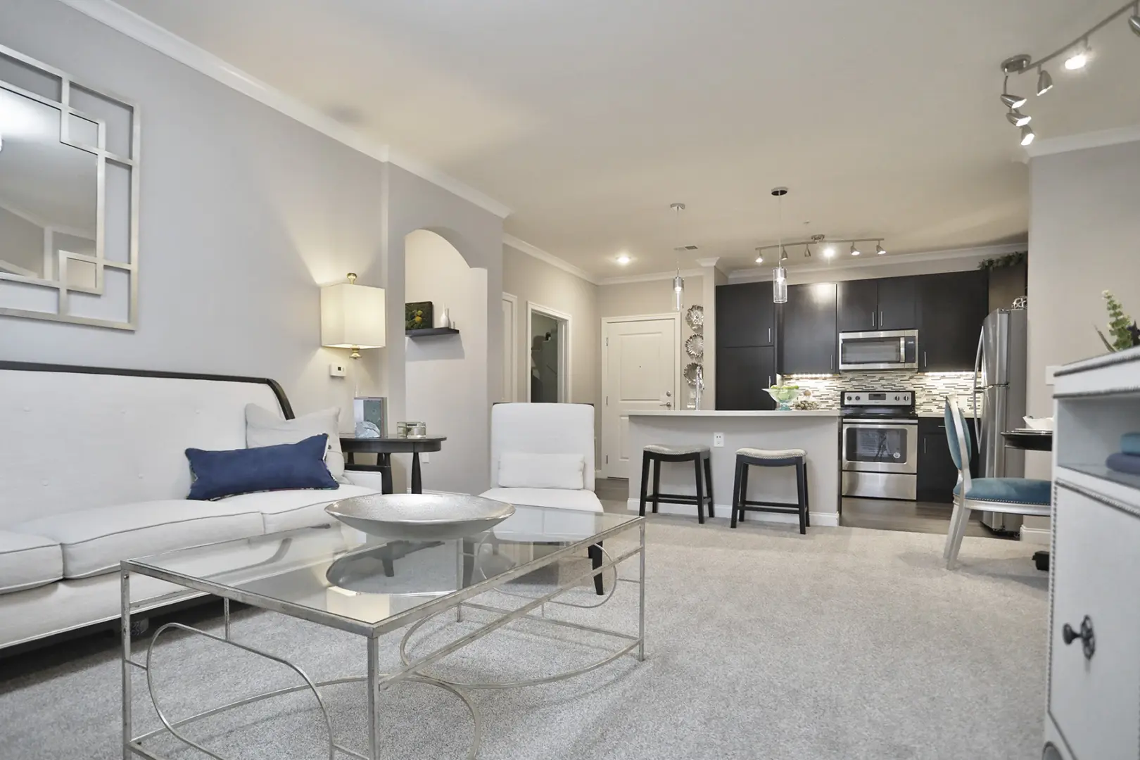 Interior of a two-bedroom home at 49Hundred Apartments featuring an open living room and kitchen with quartz countertops, stainless steel appliances, and java-stained cabinets, blending style and functionality.