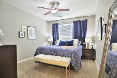 Primary bedroom at Emerald Lakes Apartments featuring a spacious layout with a large closet and a private en-suite bathroom, designed for comfort and convenience.