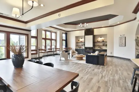 Newly updated clubhouse at Wellington Place Apartments featuring modern furnishings, a kitchenette, and stylish décor designed for relaxing or socializing.