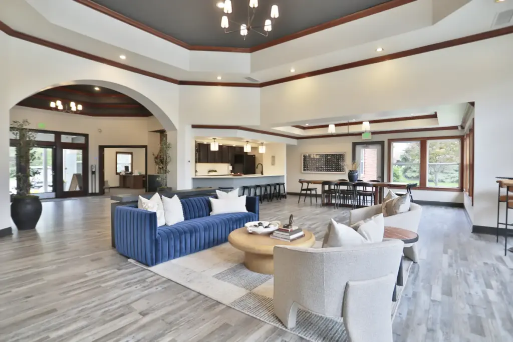 Newly updated clubhouse at Wellington Place Apartments featuring modern furnishings, a kitchenette, and stylish decor designed for relaxing or socializing.