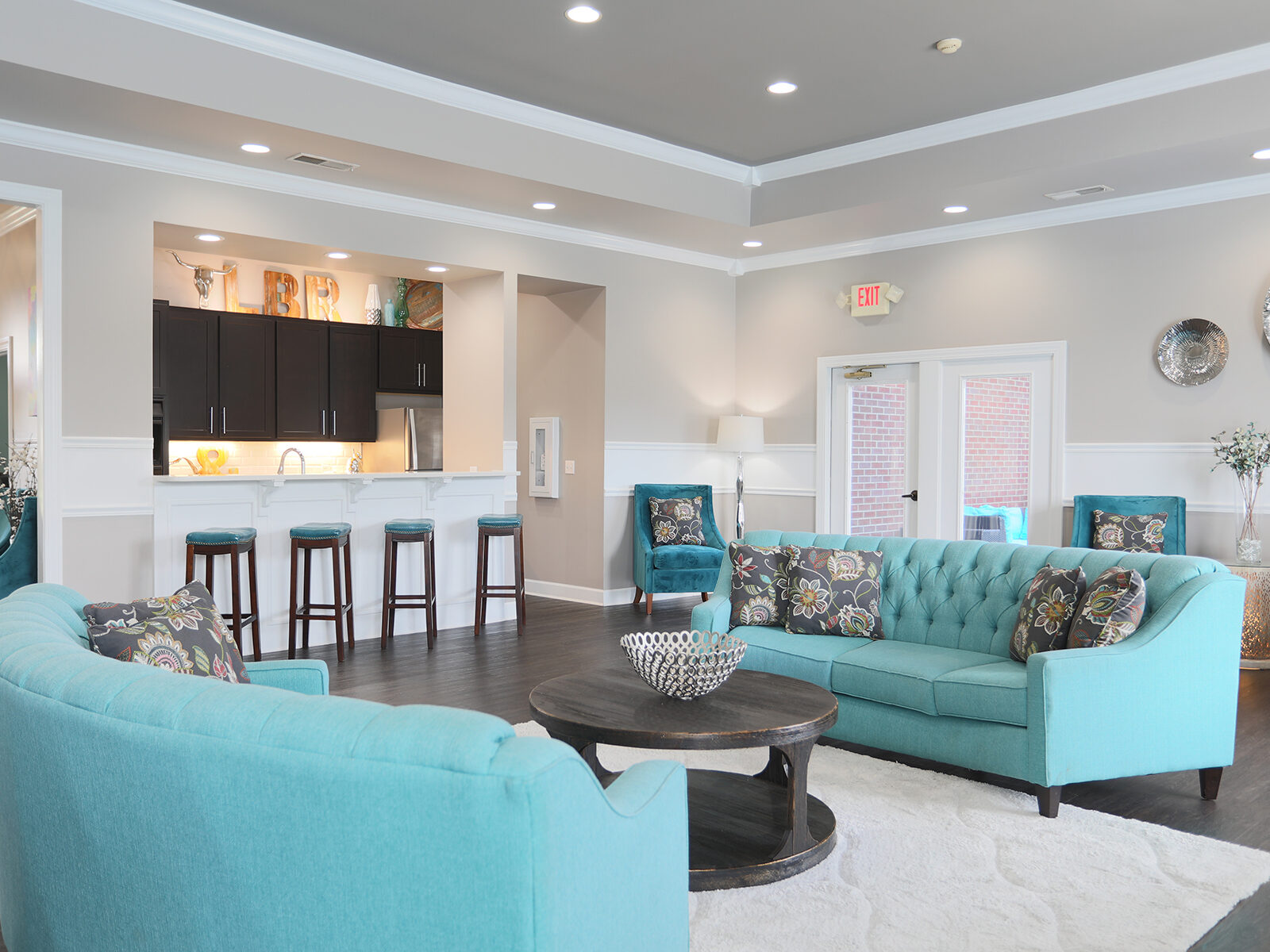 beautifully decorated clubhouse with kitchen area and seating for residents.