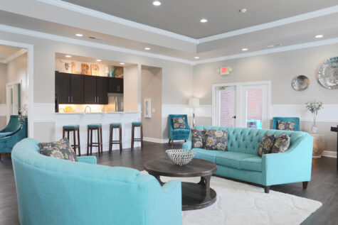 beautifully decorated clubhouse with kitchen area and seating for residents.