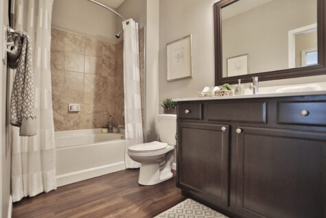Guest bathroom at Kendal on Taylorsville showcasing sleek finishes, a contemporary vanity, and a combination shower and tub for modern convenience.