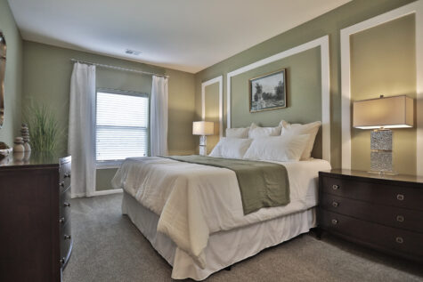 Guest bedroom at Kendal on Taylorsville featuring a spacious layout with neutral tones, large windows, and cozy modern design for a comfortable retreat.