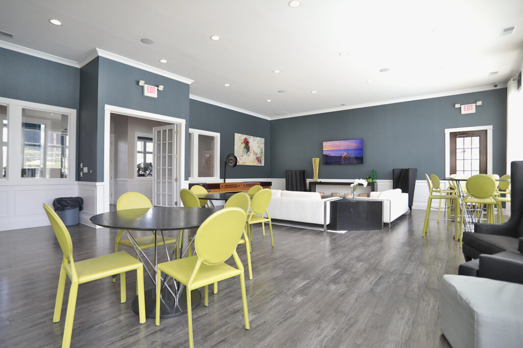 Rentable multipurpose room at Kendal on Taylorsville designed for gatherings and events, featuring comfortable seating, a shuffleboard table, and a full kitchen for entertaining.