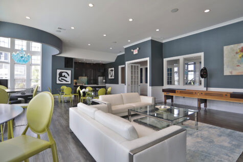 Rentable multipurpose room at Kendal on Taylorsville designed for gatherings and events, featuring comfortable seating, a shuffleboard table, and a full kitchen for entertaining.